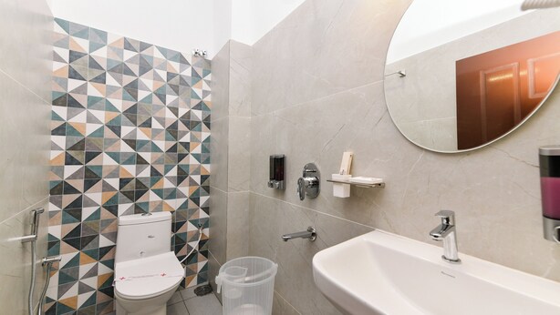 A modern bathroom with a toilet, shower, and sink. - HOTEL SHINE INTERNATIONAL (Mysore)