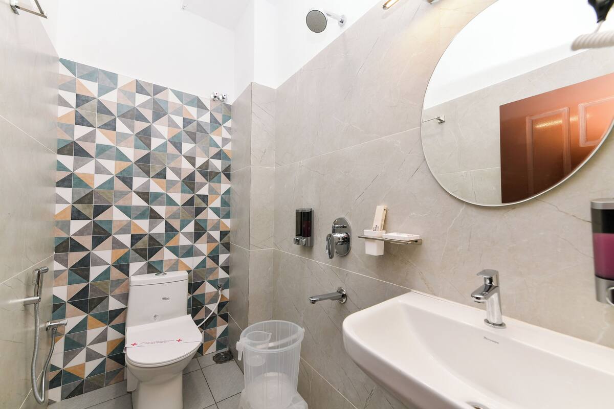 A modern bathroom with a toilet, shower, and sink.