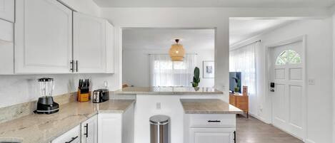 Een koelkast, een oven, een vaatwasser, kookgerei, borden en bestek