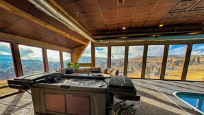 Banheira de hidromassagem com vista para a paisagem urbana através de grandes janelas.