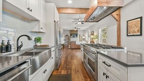 Uma cozinha moderna com eletrodomésticos de aço inoxidável, vigas de madeira e uma ilha central.