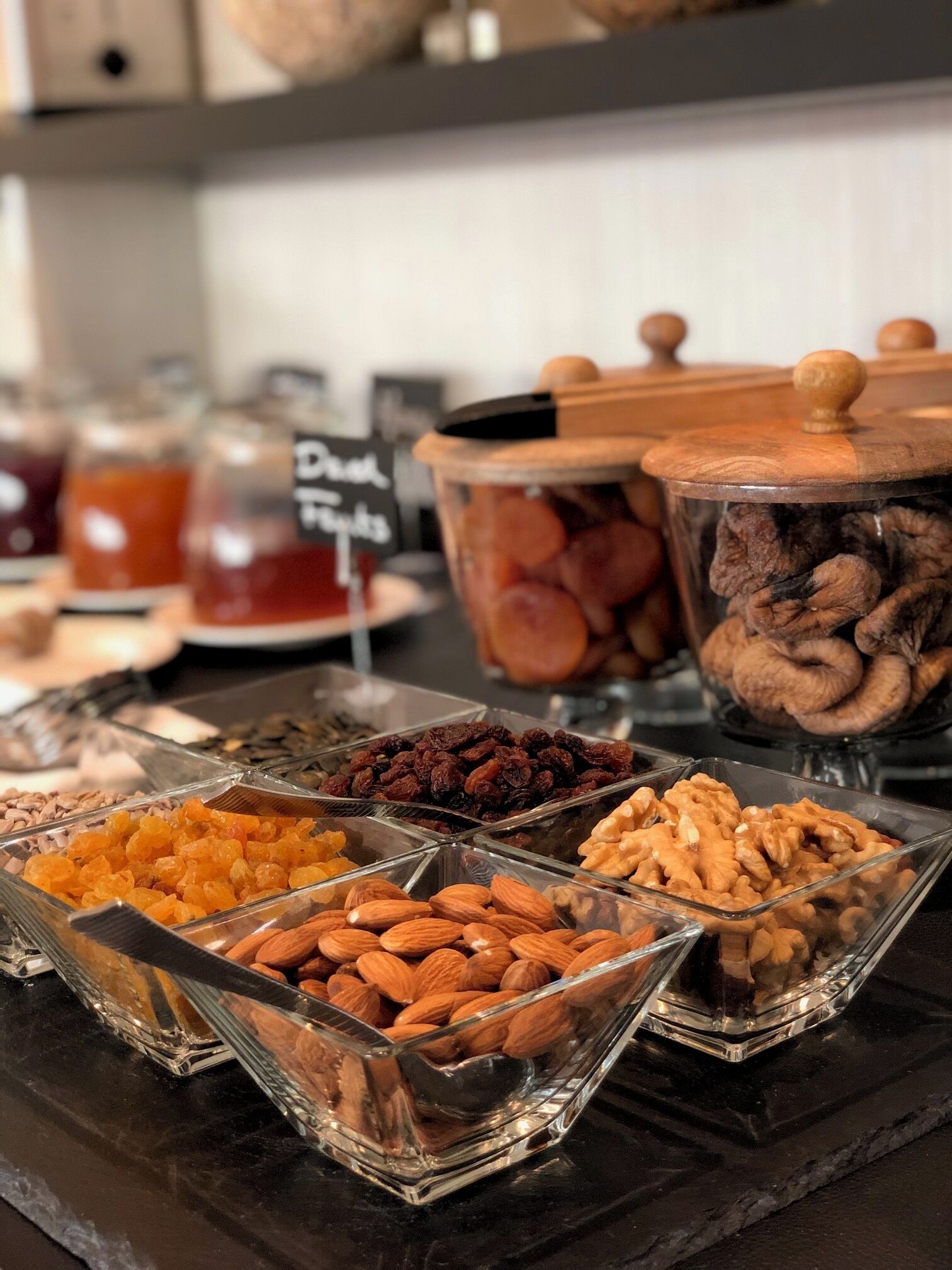 Ein Buffet mit verschiedenen Speisen, darunter Nüsse, Trockenfrüchte und andere Snacks.