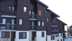 Ein mehrstöckiges Holzgebäude mit Balkonen, Fenstern und Türen.