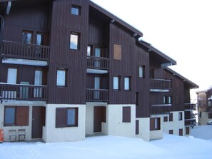 A multi-story wooden building with balconies, windows, and doors. - 300m from ski slopes, 1st floor, terrace, fireplace or stove, tv, 40m², Montchavin La Plagne (Bellentre)