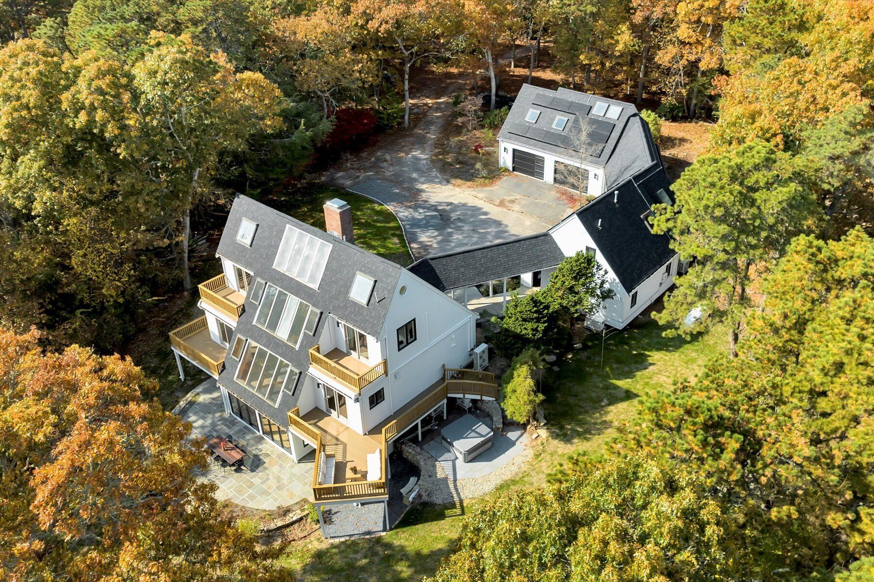 A modern two-story house with a large deck and a garage.