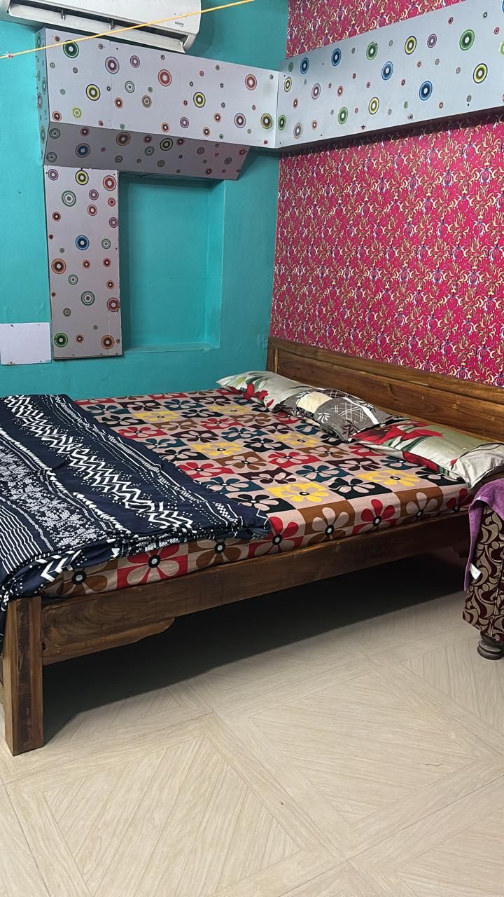 A room with a bed, a patterned wall, and a ceiling with circular designs.