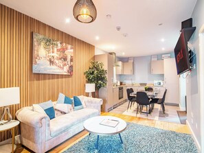 A modern living room with a sofa, coffee table, and a painting on the wall. - Cosy Sheffield Cottage Retreat 2bedroom (Sheffield)