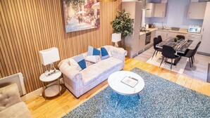 Ein modernes Wohnzimmer mit einer Couch, einem Couchtisch und einem Essbereich mit Stühlen.