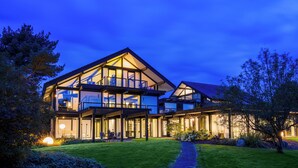 A modern two-story house with large windows and a well-lit exterior. - Villa Leonardo (Gebhardshain)