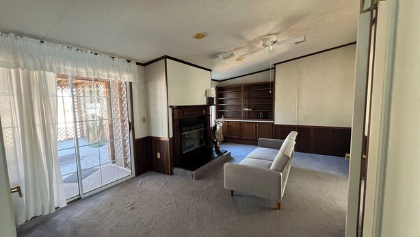 Una sala de estar con un sofá, un televisor y un mueble de madera.
