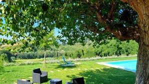 A poolside area with outdoor furniture and a view of a swimming pool.