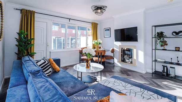 Un salon moderne avec un canapé, une table basse et un téléviseur.