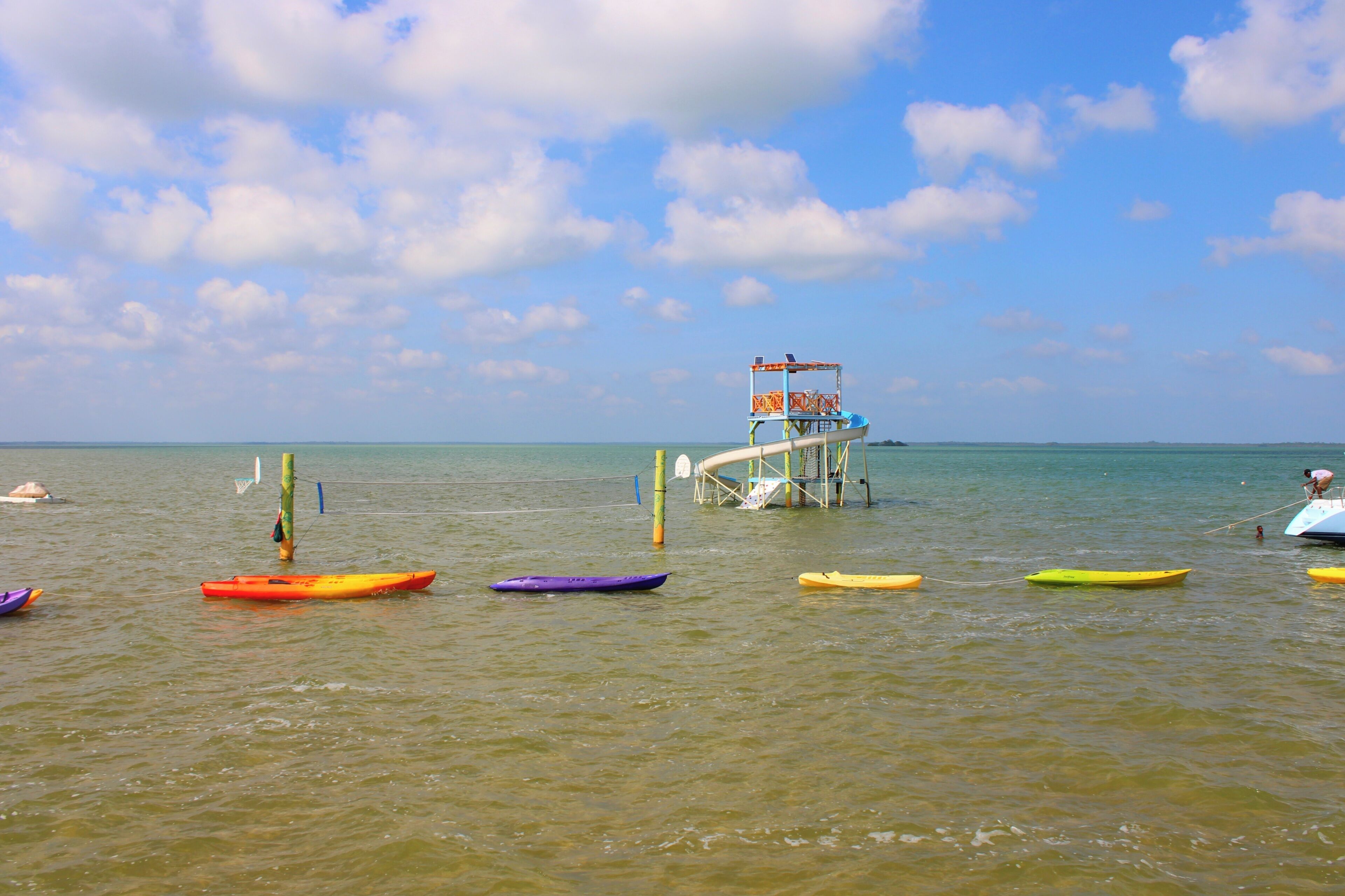 A calm sea with kayaks and a lifeguard tower.