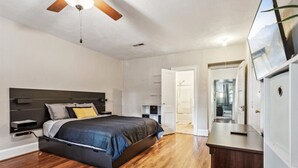 A bedroom with a bed, wooden flooring, a ceiling fan, a TV, and a wardrobe. - Family and dog friendly home, 30+ day stays (Norfolk)