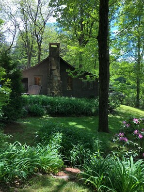 Ein rustikales Steinhaus, umgeben von üppigem Grün und einem gepflegten Garten.
