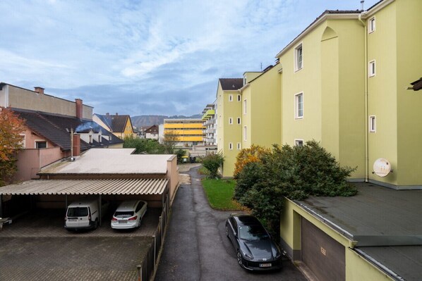 A residential street with parked cars and apartment buildings.