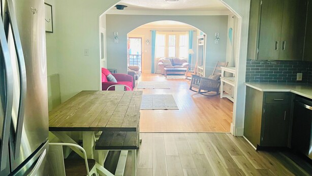 Una cocina amplia con comedor, piso de madera y vista al salón.