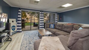 Una habitación con un ventanal grande, un sofá, una mesa de centro y una televisión.