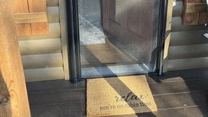 Una puerta corrediza de vidrio que da acceso a un edificio de estilo cabaña con fachada de madera.