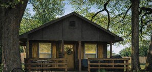 A rustic wooden cabin with a porch, a table, and a bench. - Modern luxury- Rustic Charm (Afton)