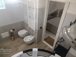 Casa de banho com bidé, sanita e lavatório.