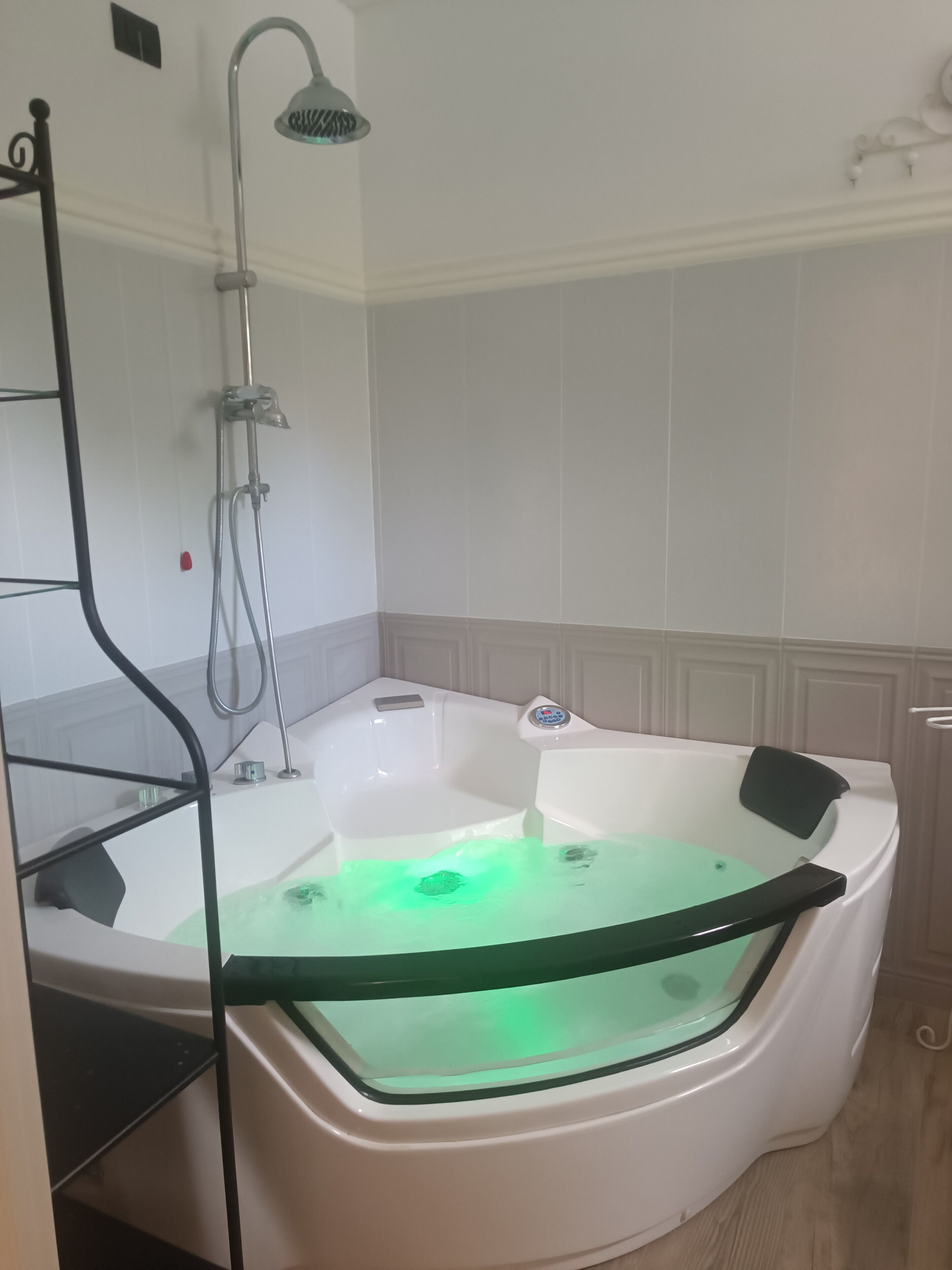 A modern bathroom with a freestanding bathtub, a glass-enclosed shower, and a built-in shelf.