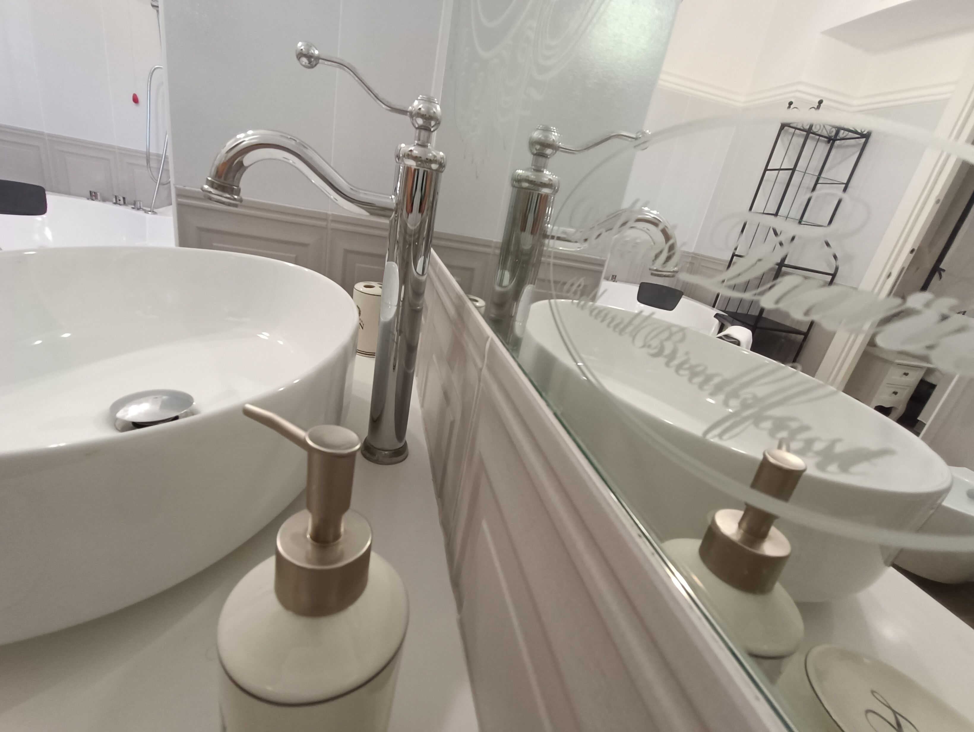 A bathroom with a large white sink, a mirror, and a toilet.