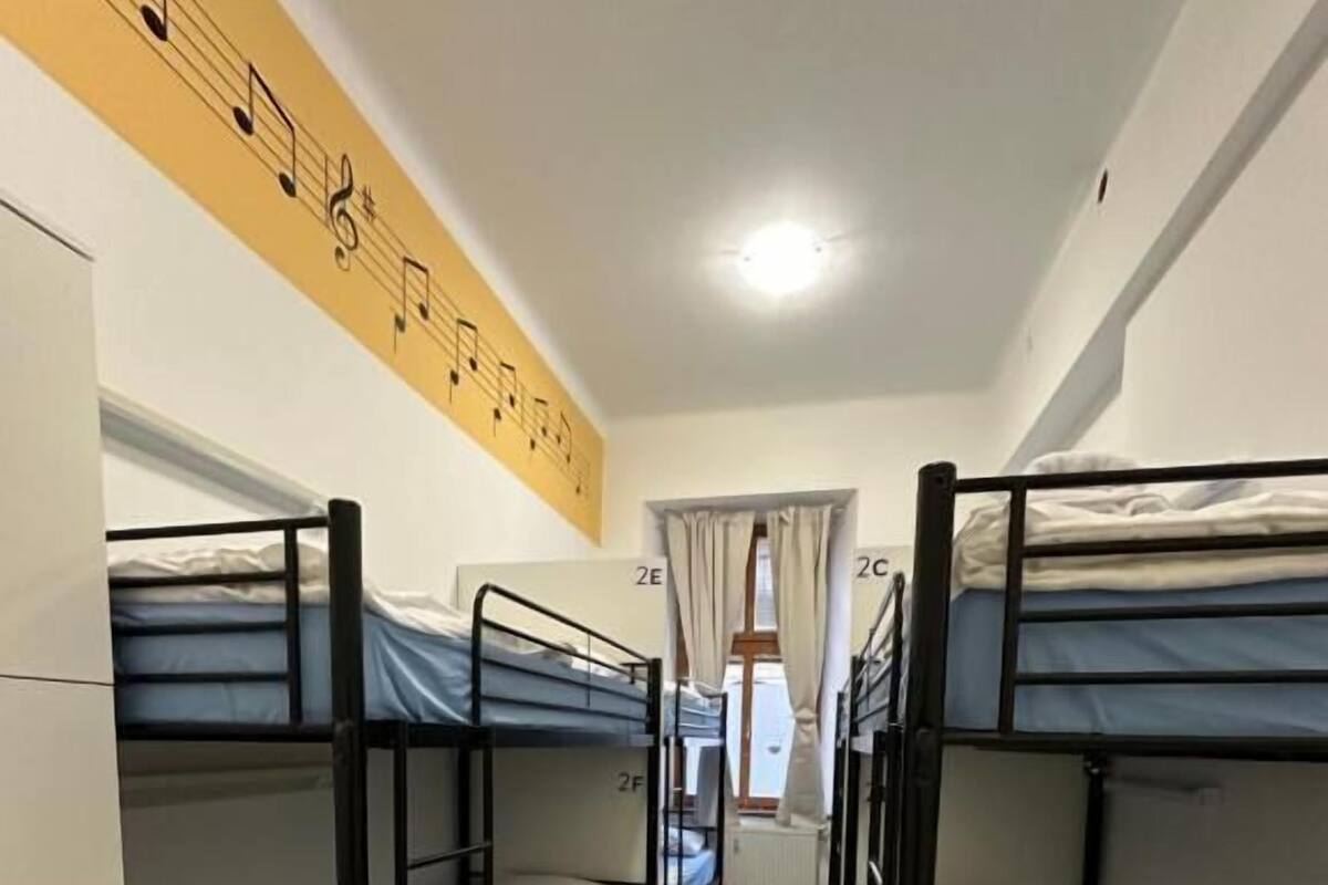 A corridor with bunk beds, a tiled floor, and a wall with musical notes.