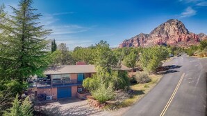 A two-story building with a blue front door, a balcony, and a garage. - Sedona Retreat:HotTub View Trail (Sedona)