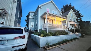 A two-story house with a front porch, a driveway, and a car parked in front. - Prime 2BR Retreat 5 Min to Brown Downtown Providence w Free Private Parking (East Providence)