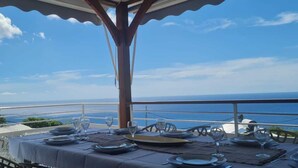 A table set for dining with a view of the ocean.