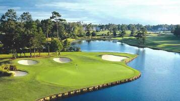 A golf course with bunkers, a water hazard, and a bridge.