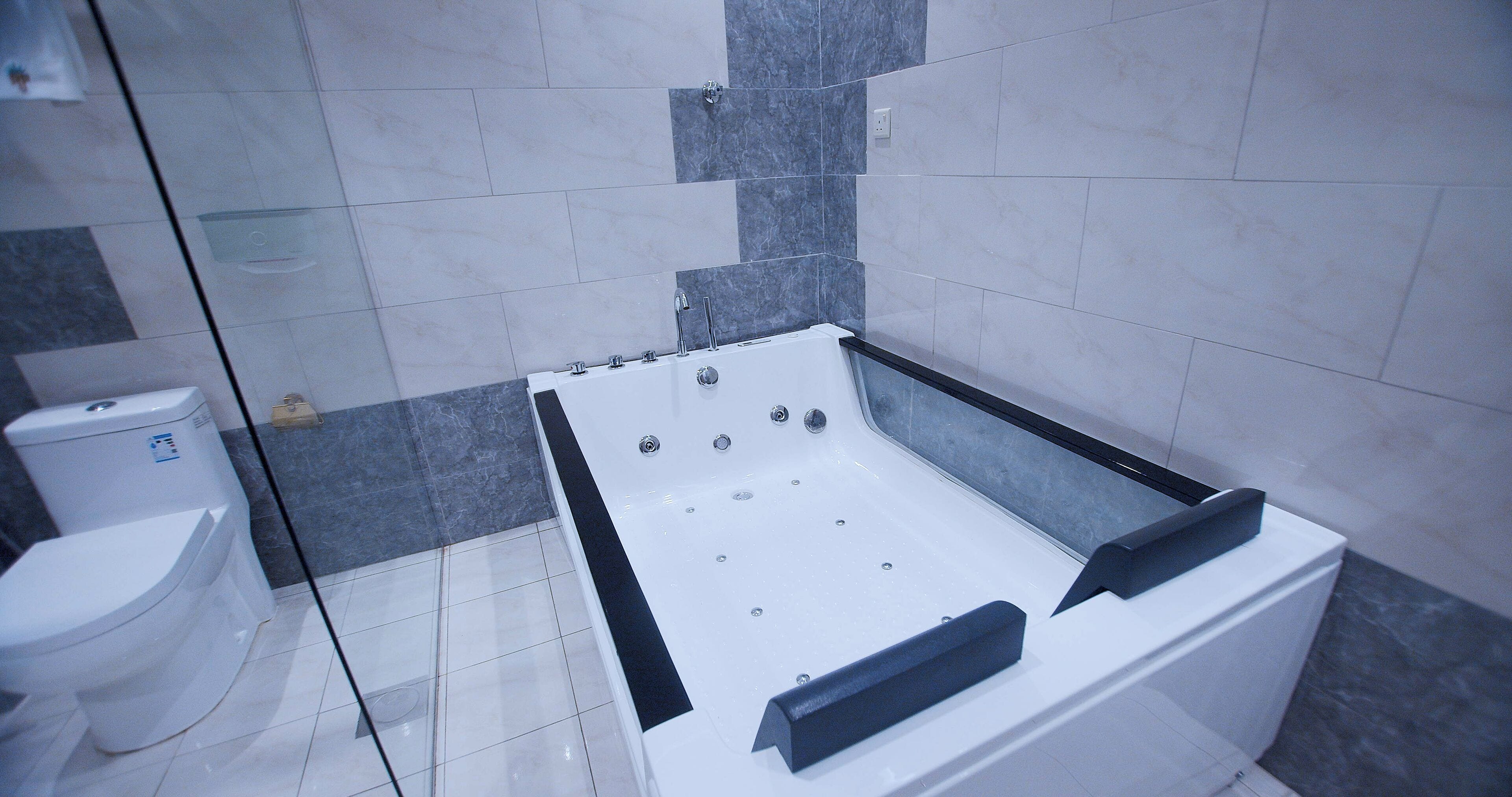 Ein modernes Badezimmer mit einer weißen Badewanne, einer Toilette und einer Duschkabine aus Glas.