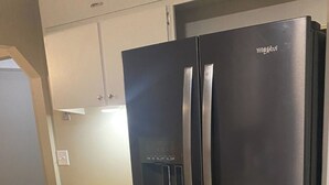 A black Whirlpool refrigerator with a freezer drawer, a double door, and a water dispenser. - Spacious Beautiful Omaha Retreat - 2BR/1BA Apartment with All-Inclusive (Omaha)