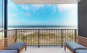 A balcony with a view of the beach and ocean. - Beachfront 2-bedroom condo with Gym, Pool, & WiFi, on  Jacksonville Beach. (Jacksonville Beach)