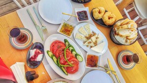 Una mesa dispuesta con diferentes platos, incluyendo huevos, verduras y pan, que sugiere una preparación para comer.