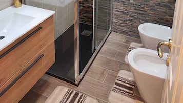 Vierpersoonskamer | Badkamer | Een douche, gratis toiletartikelen, een haardroger, handdoeken