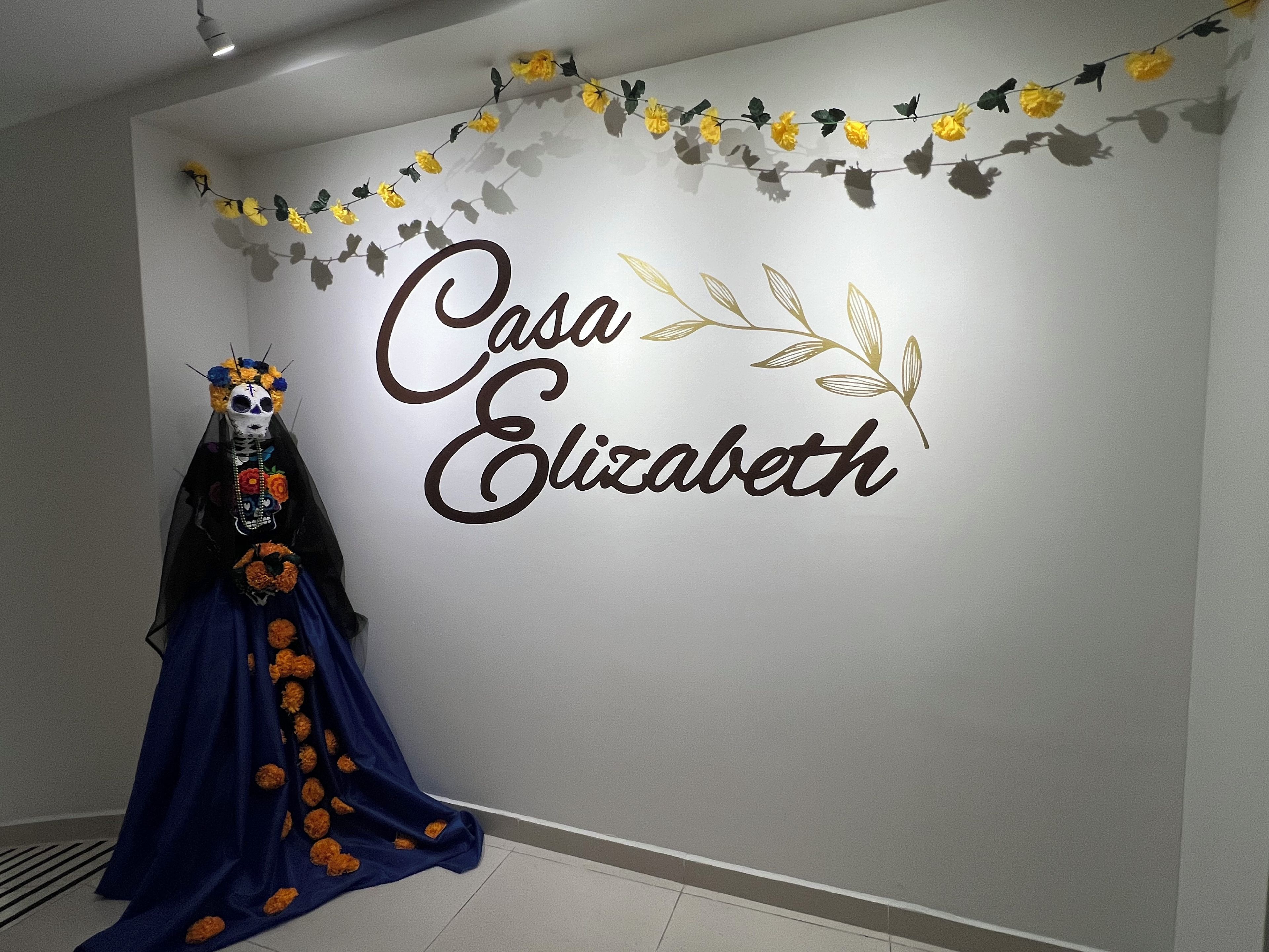 Una pared con el texto 'Casa Elizabeth' y una guirnalda decorativa.