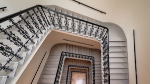 A staircase with ornate black iron railings and a geometric design. - Roosevelt Stadthaus (Vienna)