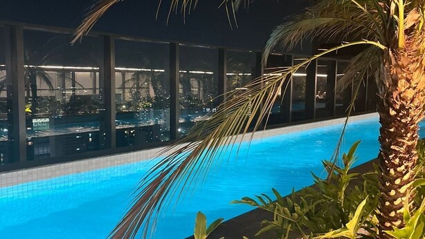A nighttime pool area with a clear view of the cityscape in the background. - Modern studio close to Allianz (Pompeia São Paulo)