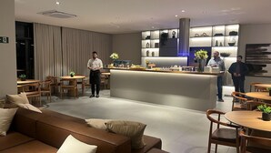 A modern hotel lobby with a seating area, a reception desk, and a bar. - Modern studio close to Allianz (Pompeia São Paulo)