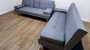 A room with a grey sofa and a television mounted on the wall. - Princesa Department. Huatulco. (Santa Cruz Huatulco.)