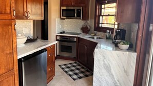 A kitchen with wooden cabinets, a microwave, an oven, a dishwasher, and a sink. -  1 bedroom guest house in quiet, gated community. (Poway)