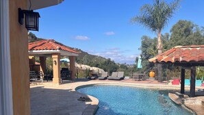 A swimming pool with lounge chairs and a covered seating area. -  1 bedroom guest house in quiet, gated community. (Poway)
