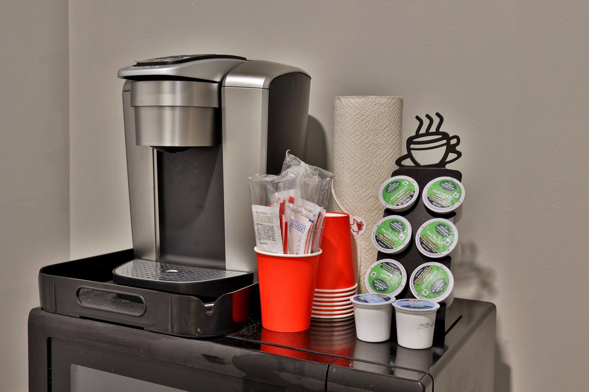 A coffee machine with disposable cups and a napkin holder.