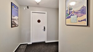 A hallway with a white door marked 631, a framed poster on the right, and a framed picture on the left.
