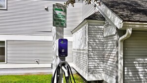 A residential building with a sign indicating a charging station for electric vehicles.