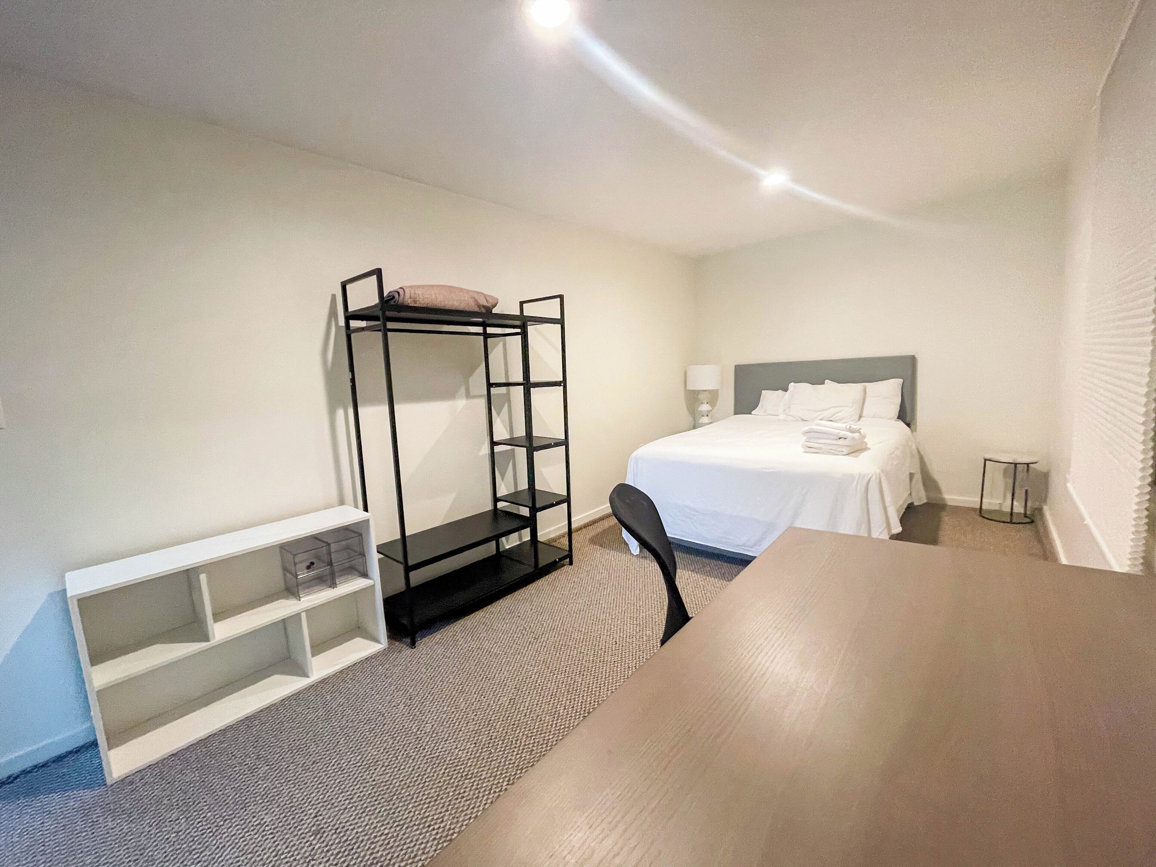 Ein Hotelzimmer mit Etagenbett, Schreibtisch, Stuhl und Nachttisch.