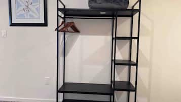 A black metal shelf unit with a top shelf, two middle shelves, and a bottom shelf.