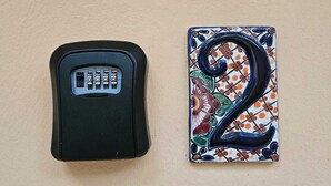 Un appareil électronique noir et un carreau décoratif portant le numéro 2.